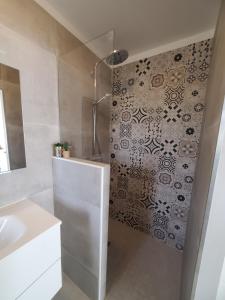 a bathroom with a white sink and a shower at Charmant studio moderne avec extérieur "Dormir en provence" in Fontvieille