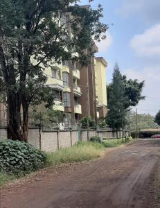 an empty road in front of a large building at Salmiya Place 2 in Nairobi