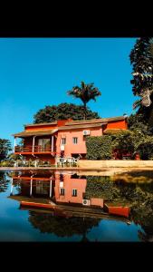 uma casa numa colina com um reflexo na água em casa Luis em São Tomé