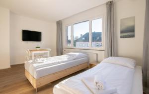 ein Hotelzimmer mit zwei Betten und einem Fenster in der Unterkunft T&K Apartments - Studio Apartments - 22 min MESSE DUS & Airport DUS in Krefeld + 21 Fotos