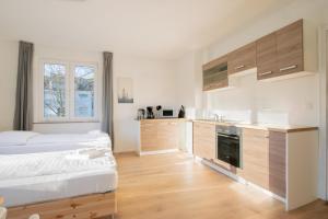 ein Schlafzimmer mit einem Bett und einer Küche in der Unterkunft T&K Apartments - Studio Apartments - 22 min MESSE DUS & Airport DUS in Krefeld