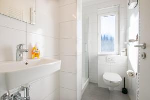 a white bathroom with a toilet and a sink at T&K Apartments - Studio Apartments - 22 min MESSE DUS & Airport DUS in Krefeld