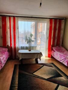 - une chambre avec deux lits et une table devant une fenêtre dans l'établissement Eleon, à Ouman