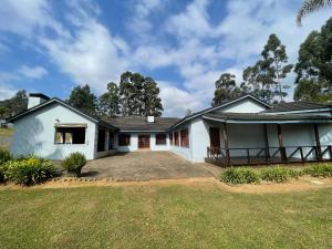 une grande maison blanche avec une grande cour dans l'établissement Boikhutsong House, à Mbabane
