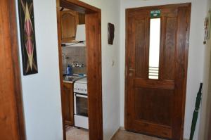 uma cozinha com uma porta de madeira e um fogão em Вила Даяна em Ribarica