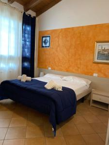 een slaapkamer met een bed met een blauwe deken bij Agriturismo Corte Bozzini in Bardolino