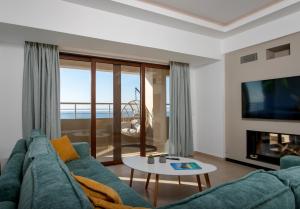 uma sala de estar com um sofá azul e uma televisão em Overview Chania with sea view and amazing sunset em Chania Town