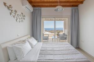 a bedroom with a bed with a view of the ocean at Sea & Stone Residence Mykonos in Platis Gialos