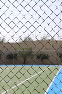a net on a tennis court with trees in the background at Hotel Villa Pascucci in Durrës