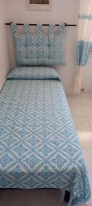 a bed with a blue comforter in a room at Appartamento vicino al mare e al centro in Alghero