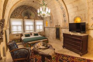 a bedroom with a bed and a tv in a room at Solo Cave Suites in Nevşehir