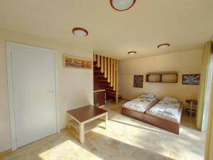 a bedroom with a bed and a table and a staircase at Namelis ir marios in Nida +8 photos