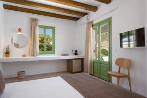 カマライにあるXerolithia Landの緑のドアと椅子が備わるベッドルーム1室