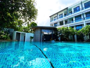 a swimming pool in front of a building at Z&Z Resort in Rawai Beach