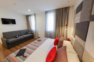 a bedroom with a large bed and a couch at Hôtel Méditerranée in Calvi