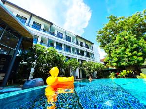 a rubber duck toy sitting on the side of a swimming pool at Z&Z Resort in Rawai Beach