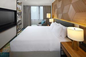 Cette chambre comprend un grand lit et une télévision. dans l'établissement Holiday Inn Cebu City, an IHG Hotel, à Cebu