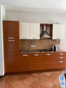 een keuken met houten kasten en een wastafel bij Agriturismo Corte Bozzini in Bardolino