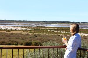a woman standing on a balcony holding a glass of wine at Fontsanta Hotel Thermal & Spa - Adults Only in Colònia de Sant Jordi