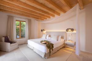 a bedroom with a large white bed and a window at Fontsanta Hotel Thermal & Spa - Adults Only in Colònia de Sant Jordi