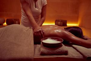 a woman laying on a bed getting a massage at Fontsanta Hotel Thermal & Spa - Adults Only in Colònia de Sant Jordi