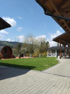 a pavilion with a green lawn and a building at Apartamenty Równia 2 in Ustrzyki Dolne