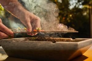 a person is cooking food on a grill at Fontsanta Hotel Thermal & Spa - Adults Only in Colònia de Sant Jordi