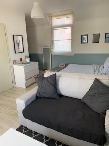 a bedroom with a bed and a couch with pillows at Appartement Design V Port de Tréboul-Douarnenez in Douarnenez