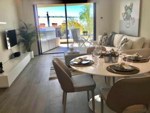 uma sala de estar com uma mesa e cadeiras e um sofá em Luxury Apartment Juliano - The View Fuengirola em Fuengirola