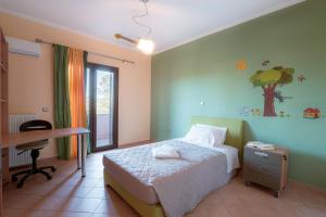 1 dormitorio con cama, escritorio y mesa en VERDE VILLA, en Gaïtánion
