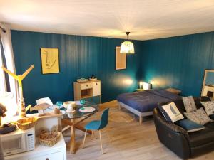 ein Wohnzimmer mit einem Sofa, einem Bett und einem Tisch in der Unterkunft Maison calme "entre terre et mer" - proche gare - stationnement - jardin in Saint-Brieuc