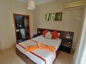 a bedroom with a bed with orange towels on it at Le Choisy Mauritius in Mont Choisy
