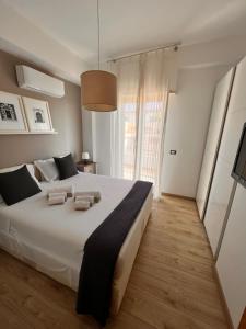 a large white bed in a room with a large window at Casa Vitale in Aci Castello