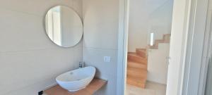a bathroom with a white bowl sink and a mirror at Villaggio Camping Oasi in Vieste