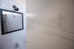 a bathroom with a mirror and a toilet in it at Dandelion hostel in Zadar