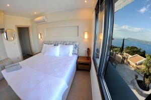 a bedroom with a bed and a view of the ocean at Stone Crafted Luxury Villas in Nikiana +98 photos