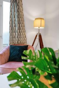 uma sala de estar com uma cadeira, um candeeiro e uma planta em Cheerful Stays - Livingston - 4 Bedroom 3 Bath home em Livingston