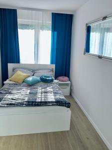 een slaapkamer met een bed met blauwe gordijnen bij Sztormowa Apartment in Gdańsk