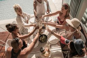 a group of people sitting around a table with drinks at Mossa Well Being Hotel - Heated pool and Wellness Spa in Kato Daratso