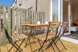 d'une table et de chaises en bois sur un balcon. dans l'établissement Cheerful Stays - Livingston - 4 Bedroom 3 Bath home, à Livingston