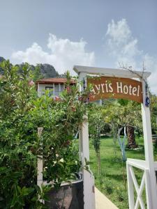a sign for a vts hotel in a garden at Ayris Hotel Çıralı in Cıralı