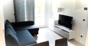 un soggiorno con divano e TV a schermo piatto di My Holiday - Alessandra Residence - Domaso a Domaso