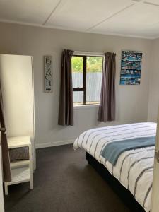 Säng eller sängar i ett rum på Kiwi beach bach