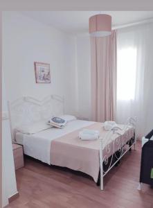 una camera con un letto bianco e una finestra di Residence La Perla Marzamemi a Pachino