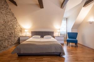 - une chambre avec un lit et une chaise bleue dans l'établissement Old Town - Muurivahe Apartment, à Tallinn