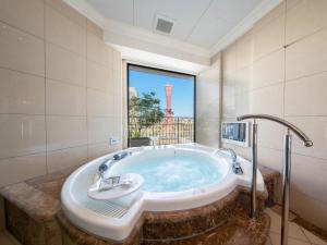 a bath tub sitting next to a large mirror at Hotel La Suite Kobe Harborland in Kobe