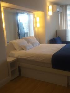 Un dormitorio con una gran cama blanca con ventana. en Star house, en Batumi