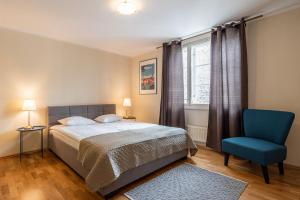 - une chambre avec un lit et une chaise bleue dans l'établissement Old Town - Muurivahe Apartment, à Tallinn