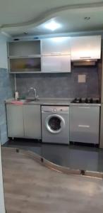 a kitchen with a stove and a washing machine at Арбат in Almaty