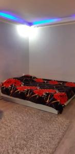 a bed with a black and red blanket on it at Арбат in Almaty